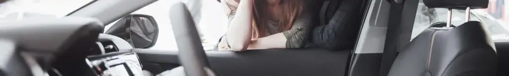 Banner of couple looking leaning on the open window of a car