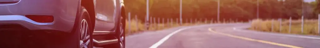 Car driving on an open forest road banner