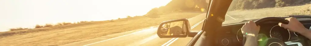 Man driving on an open road in the sunset